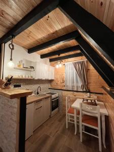 uma cozinha com tectos em madeira e uma mesa e cadeiras em Durmitorska zora em Žabljak