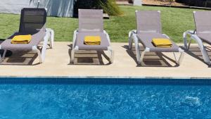 two lawn chairs sitting next to a swimming pool at Villa Clara in Cap d'en Font