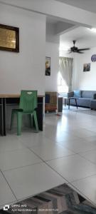 a living room with a green chair and a couch at Hana Homestay The Heights Residence in Ayer Keroh