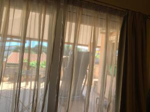 - une fenêtre avec des rideaux offrant une vue sur la cour dans l'établissement Sirem Boutique Apartament, à Assemini