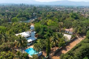 - une vue aérienne sur une villa avec une piscine et des arbres dans l'établissement StayVista's Santoni Farms - Riverside Bliss with Pool, Orchard & Activities, à Karjat