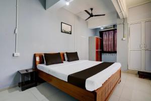 ein Schlafzimmer mit einem großen Bett in einem Zimmer in der Unterkunft OYO Hotel Sama Residency in Vadodara