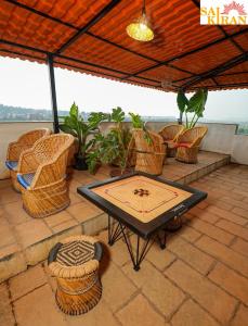a patio with a table and wicker chairs at Saikiran Hotel in Mapusa