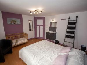 ein Schlafzimmer mit einem großen Bett und einer Leiter in der Unterkunft Spacious mansion in Waimes with sauna in Weismes