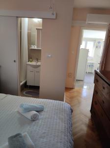 ein Schlafzimmer mit einem Bett und einem Waschbecken sowie ein Badezimmer in der Unterkunft Apartment Brezak in Lastovo