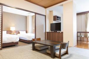 富士河口湖町にあるKawaguchiko Park Hotelのベッドとテーブル付きのホテルルームとベッドルーム1室が備わります。