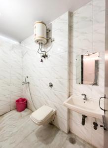 ein weißes Bad mit einem WC und einem Waschbecken in der Unterkunft JP House In Shakarpur in Neu-Delhi