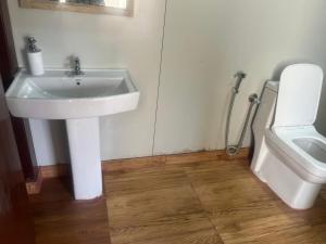 a bathroom with a sink and a toilet at Reys Cafe and Boutique Cottage - A Jungle Stay in Hawālbāgh