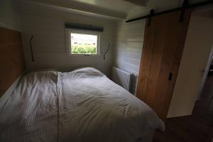 a bed in a small room with a window at Zeer ruim 6-persoons vakantiehuis met overdekte veranda in Epe