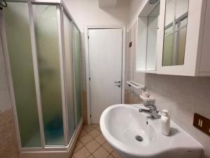 een badkamer met een wastafel en een glazen douche bij Residence Il Pantheon - Artemide in Marina di Fuscaldo