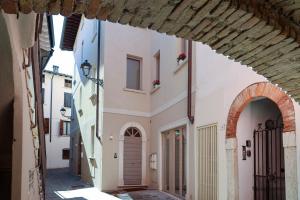 an alley in an old town with an archway at Vicolo dei Signori By Case al Lago in Desenzano del Garda