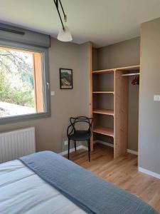 1 dormitorio con cama, ventana y silla en Refuge au coeur des Vosges en Aumontzey