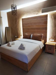 a bedroom with a large bed with a wooden headboard at Villa MATA - 600m² with Private Pool and Jacuzzi in Kalithies
