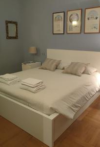 a white bed with towels on top of it at Apartments Velasca in Milan