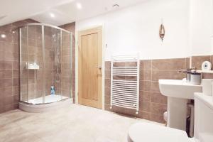 a bathroom with a shower and a toilet and a sink at WILLOW SNUG - Trearddur Bay COSY apartment in Trearddur +15 photos