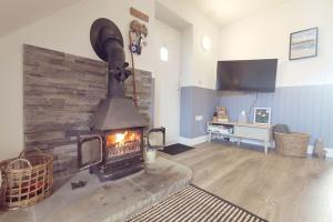a living room with a fireplace and a television at WILLOW SNUG - Trearddur Bay COSY apartment in Trearddur