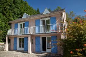 a house with blue doors and a balcony at L'ECRIN DU LAC - L'Ortencia in Mazamet +5 photos