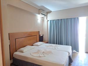a hotel room with two beds and a window at Bristol Apartments in Kos Town