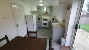 a small kitchen with a table and a refrigerator at Lovely 3 Bedroom House in Greater Manchester in Manchester
