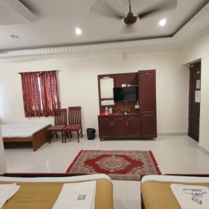 - un salon avec un lit et un miroir dans l'établissement Hotel Harish, à Rameswaram