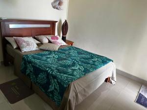a bed with a green blanket and pillows on it at Blue sea in Ruisseau Créole +2 photos