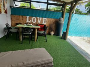 a room with a table and chairs on a green floor at Blue sea in Ruisseau Créole