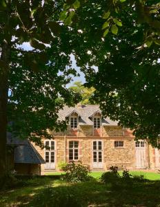 a large brick house with white windows and trees at ABBAYE DE BLANCHELANDE in Neufmesnil