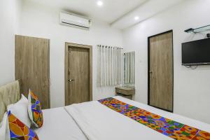 a bedroom with a bed and a flat screen tv at FabHotel Angeethi in Aurangabad