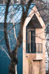 a small house with a large window on the side of it at Hakuba Hibiku Chalet by Jade Group in Hakuba
