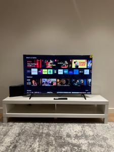 a flat screen tv sitting on a white entertainment center at Luxury Apartment - 2 minute walk from the O2 Arena in London