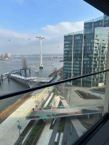 una ventana con vistas a un edificio con río en Luxury Apartment - 2 minute walk from the O2 Arena en Londres