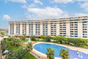 un edificio de apartamentos con una gran piscina y palmeras en Beach 75 metres away Playa a 75 metros, en Valencia