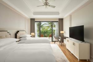 a bedroom with two beds and a flat screen tv at Danang Marriott Resort & Spa, Non Nuoc Beach Villas in Da Nang