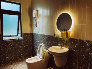 een badkamer met een wastafel, een toilet en een spiegel bij Moon homestay.dalat in Da Lat