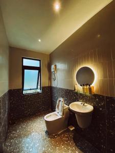 een badkamer met een toilet, een wastafel en een raam bij Moon homestay.dalat in Da Lat