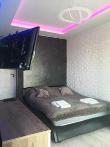 um quarto com uma cama e uma televisão de ecrã plano em IGO-Apartament- 2 sypialnie i Salon em Suwałki