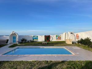 una villa con piscina di fronte a un edificio di Dar Riahi Ras Jbal a Raʼs al Jabal