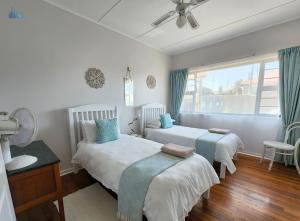 a bedroom with two beds and a window at Gonubie Guest Cottages in East London