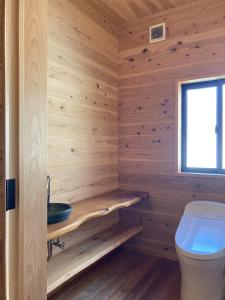 天草的住宿－Amakusa Port Ebisu House -天草 自然素材の一軒家えびすHOUSE-，小木屋浴室设有卫生间和窗户。