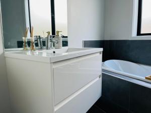 a white bathroom with a sink and a toilet at Modern Comfy 3 Bedrooms House in Chartwell in Hamilton