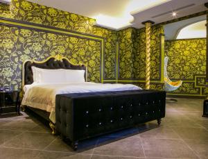 1 dormitorio con 1 cama con papel pintado de oro en All-Ur Boutique Motel - Hualian Branch en Jian