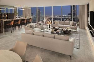 a living room with couches and a bar with a view at Sheraton Grand Hotel, Dubai in Dubai