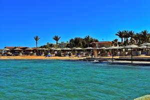 ein Wasserkörper mit Sonnenschirmen und ein Strand in der Unterkunft Al Dora Boutique hotel in Hurghada