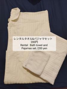 un asciugamano bianco con un cartello sopra di セルフチェックイン Guest House SHUKUGO UTSUNOMIYA a Utsunomiya