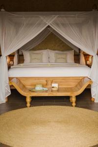- un grand lit dans une tente avec un tapis dans l'établissement Bali Palms, Tabanan, à Tabanan