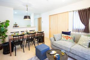 a living room with a couch and a table at シンプルでおしゃれなインテリアが光る4LDKの一軒家まるまる貸し切り！最大12名まで宿泊可能！ in Tokeshi