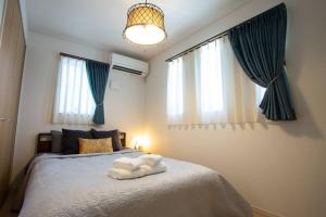 a bedroom with a bed with towels on it at シンプルでおしゃれなインテリアが光る4LDKの一軒家まるまる貸し切り！最大12名まで宿泊可能！ in Tokeshi