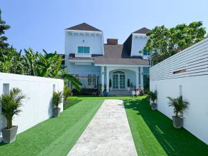 una casa con un cortile con erba verde di White Castle a Panwa Beach
