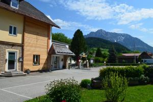 a building with a parking lot in front of a mountain at Hotel Garni Familie Gruber in Spital am Pyhrn