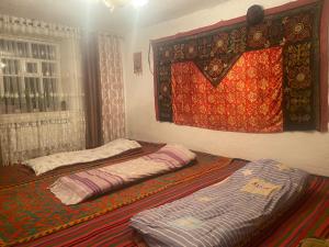 dwa łóżka siedzące obok okna w pokoju w obiekcie Guest House Aitunuk w mieście Kyzylemgek
